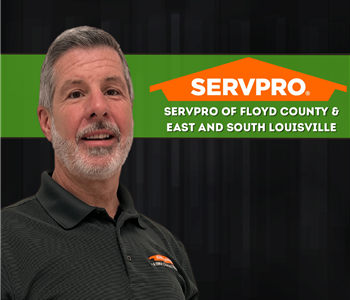 man in SERVPRO shirt smiling at camera with black background and SERVPRO logo